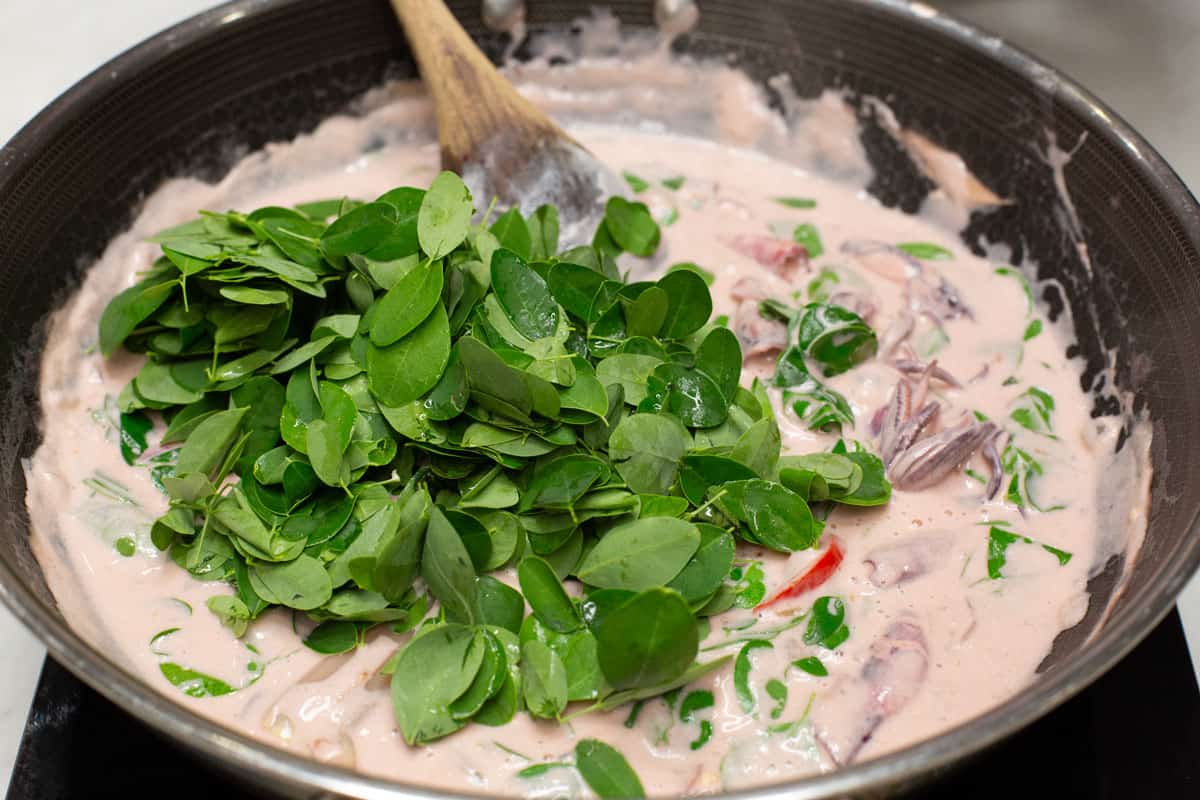 Malunggay leaves in the squid and coconut milk mixture.