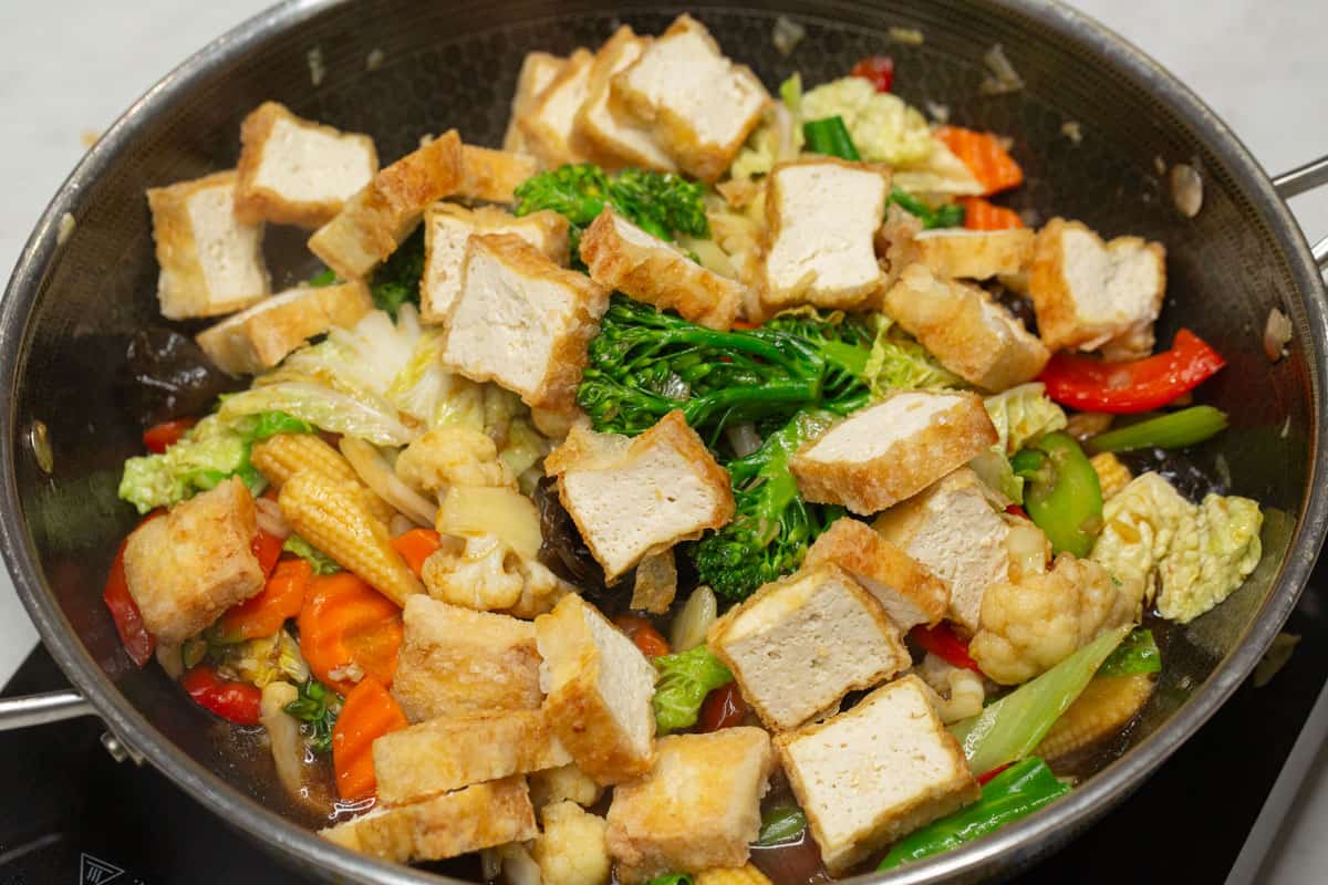 Tofu and stir-fried vegetables in the wok.