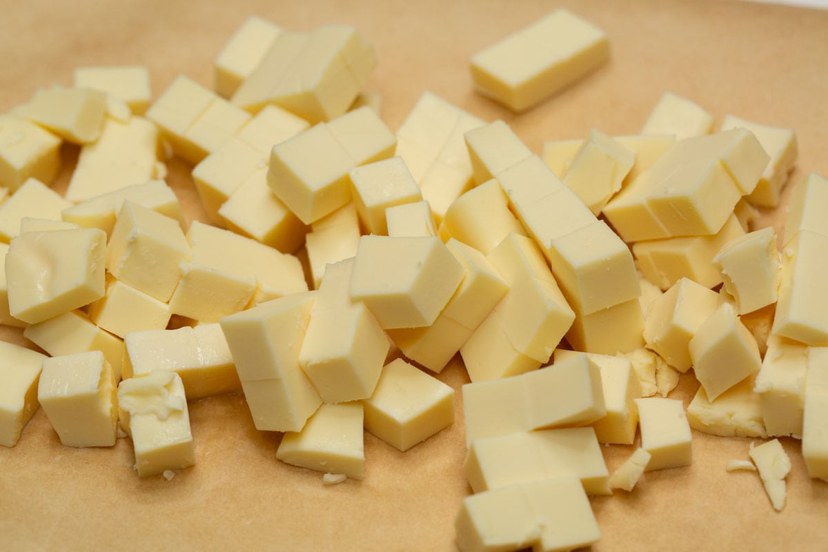Cut up cheese on a parchment paper.