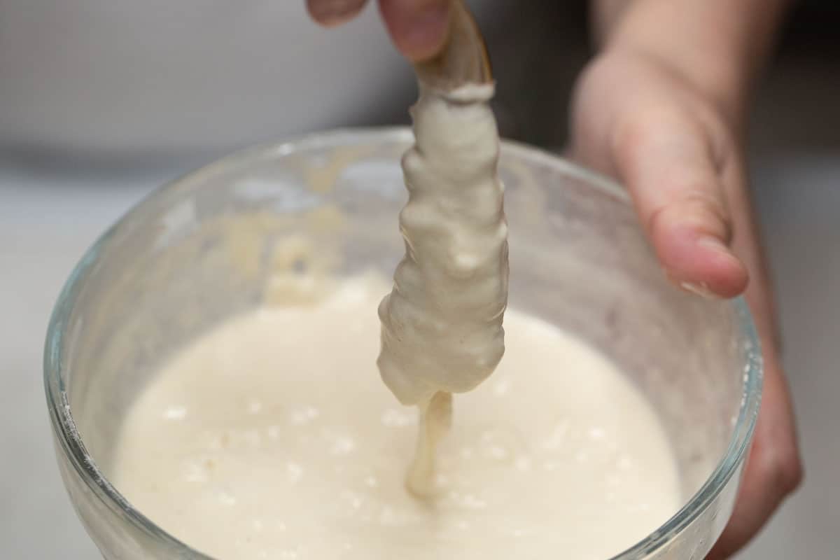 Dipping the shrimp in the batter.