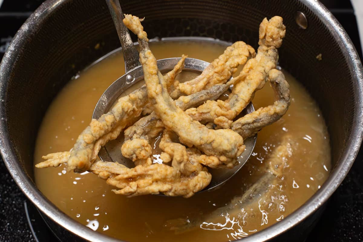 Straining the fried fish after the first fry.