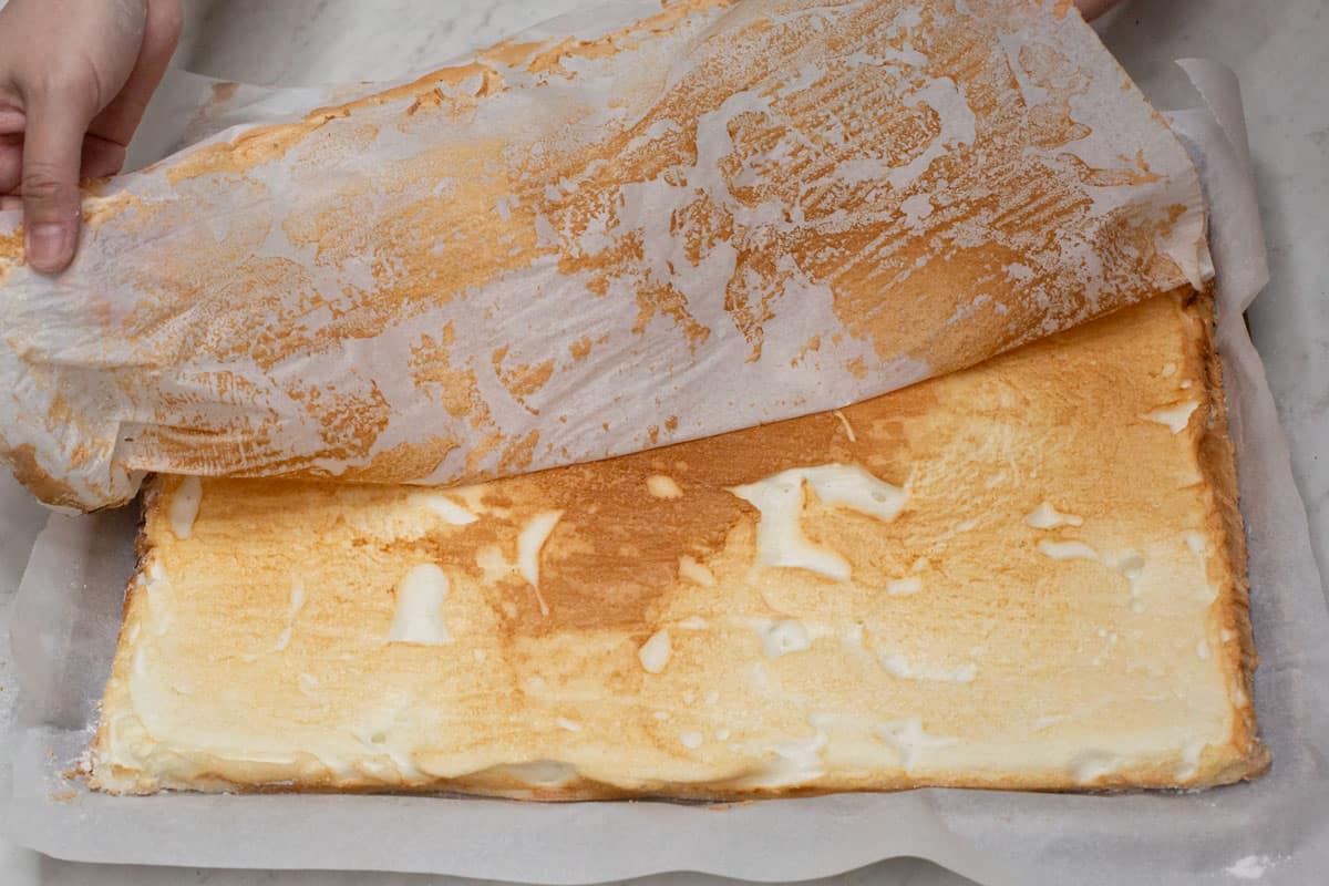 Peeling the parchment paper off the baked meringue.