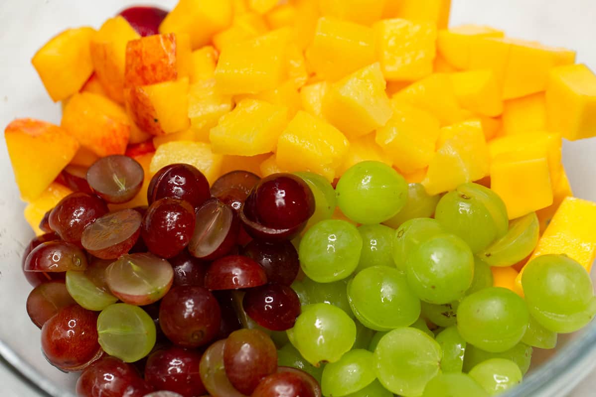 Cut up fresh fruits in a bowl.