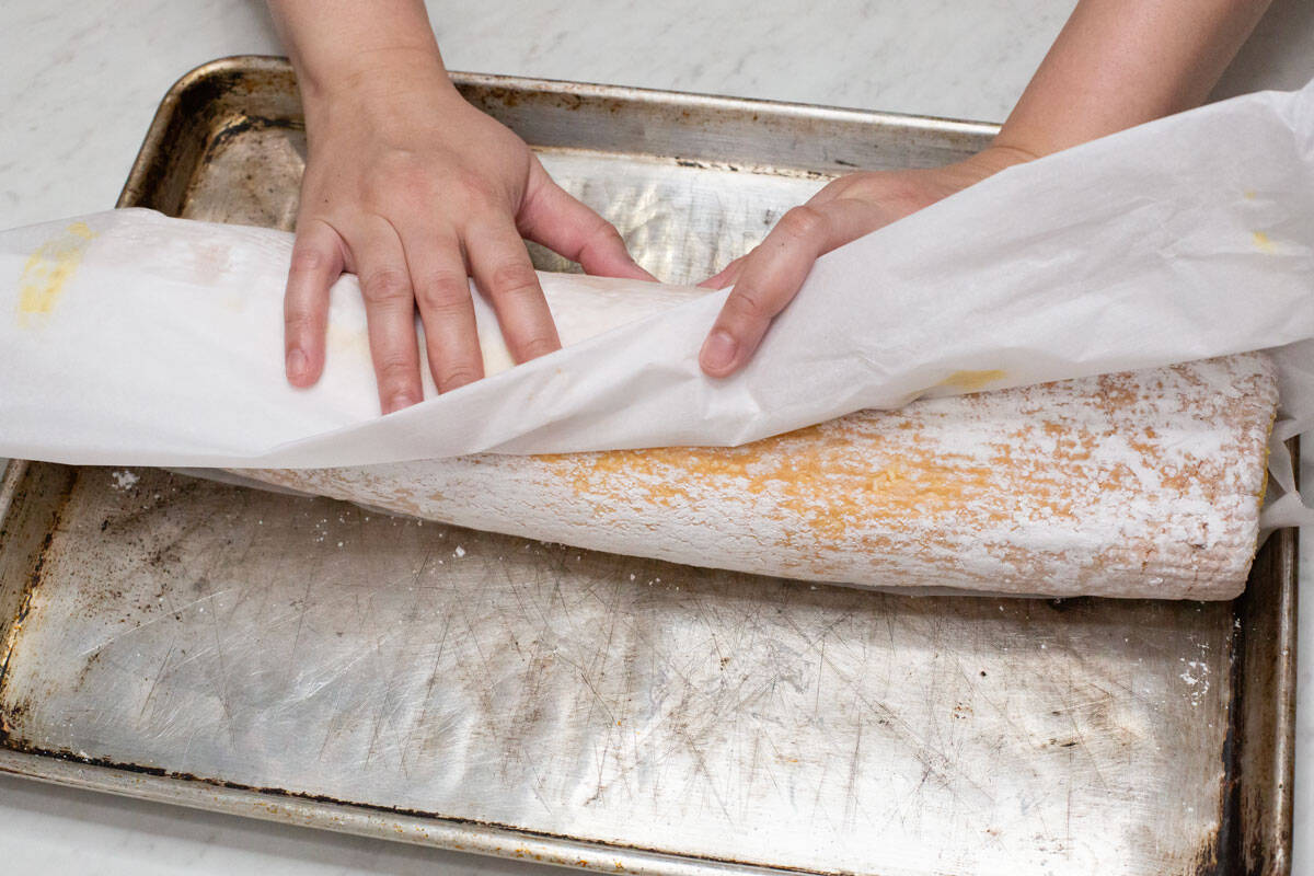 Rolling the filled meringue on the baking sheet.