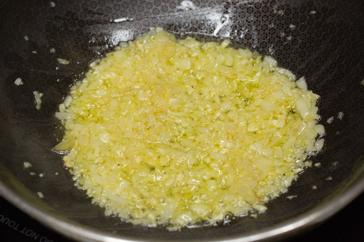 Sautéing the aromatics in a wok.