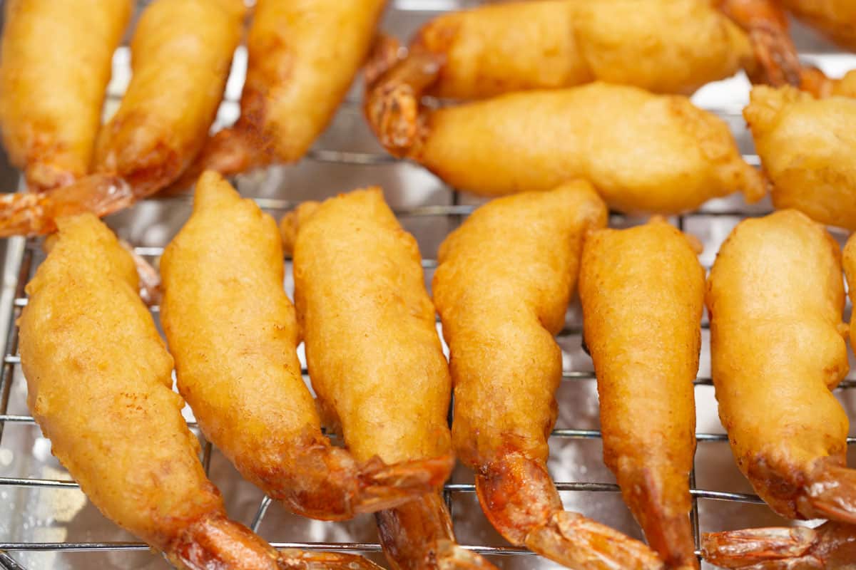 Draining the fried shrimp on a wire rack.