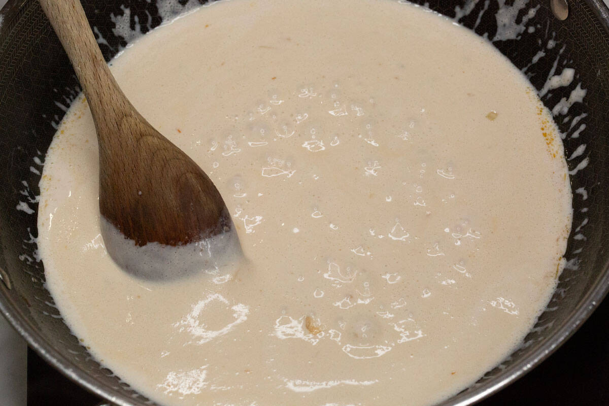 simmering coconut milk in a wok