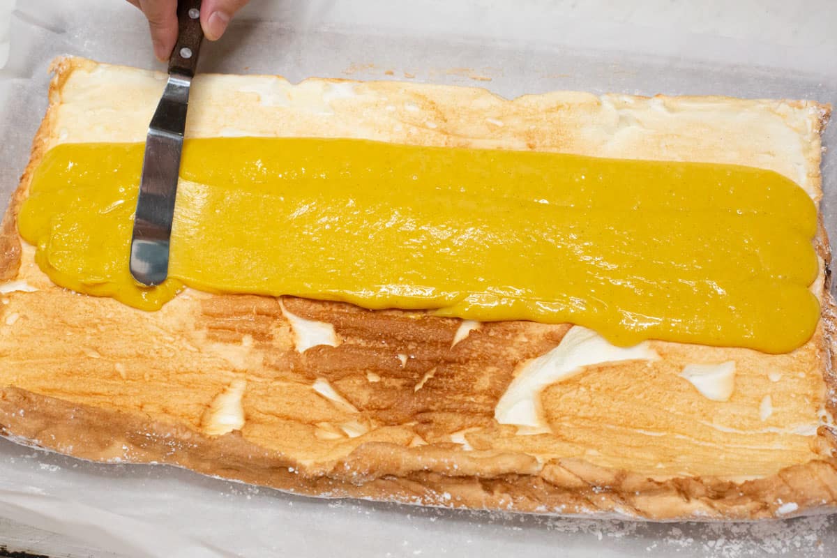 Spreading the custard filling over the baked meringue.