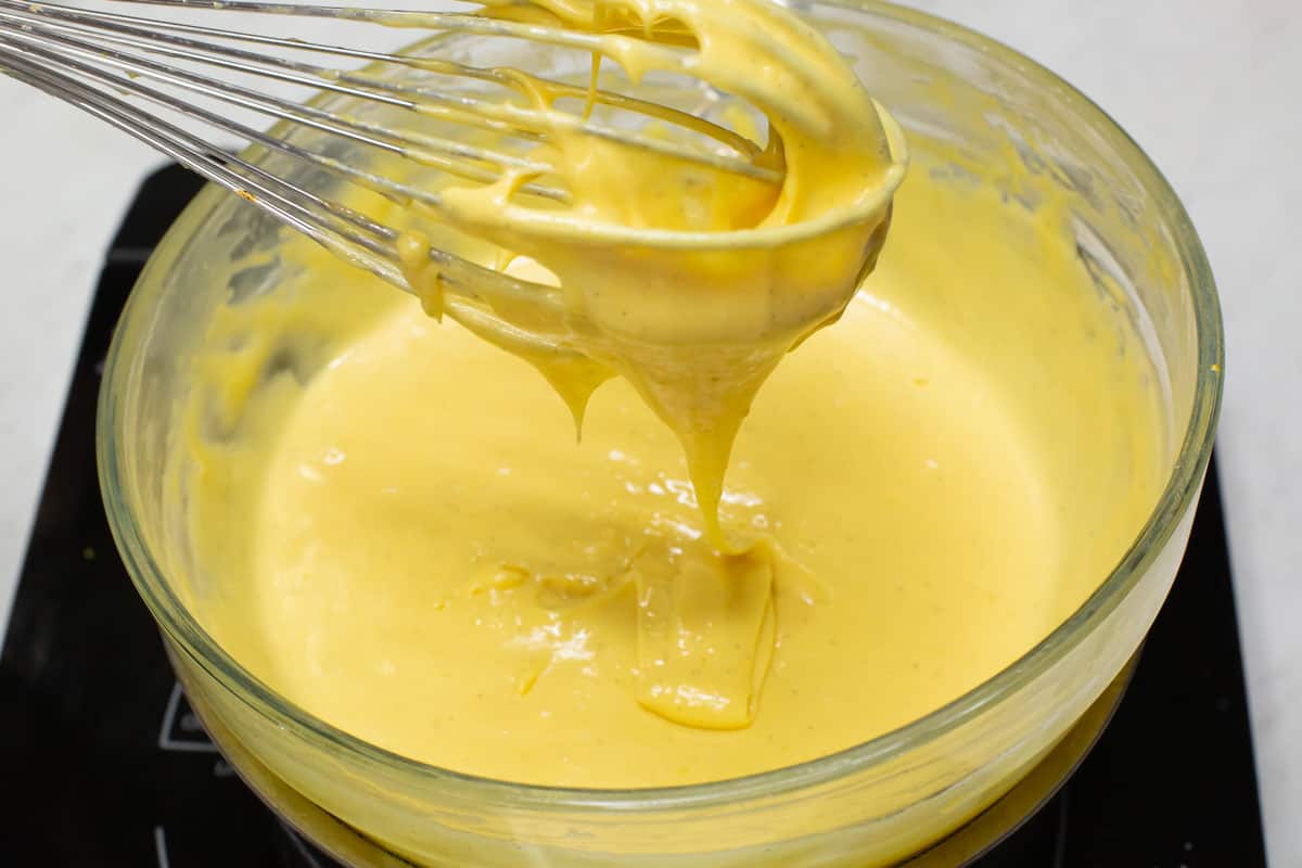 Lifting the whisk with the thickened custard filling.