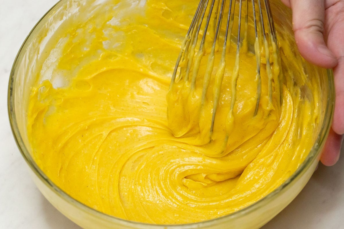 Mixing the cooled custard in the bowl.
