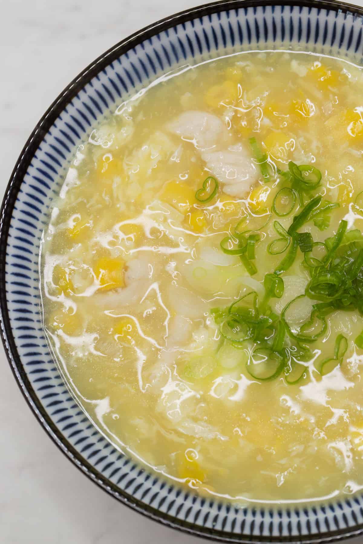 Chicken and Corn Soup in a bowl with sliced scallions.