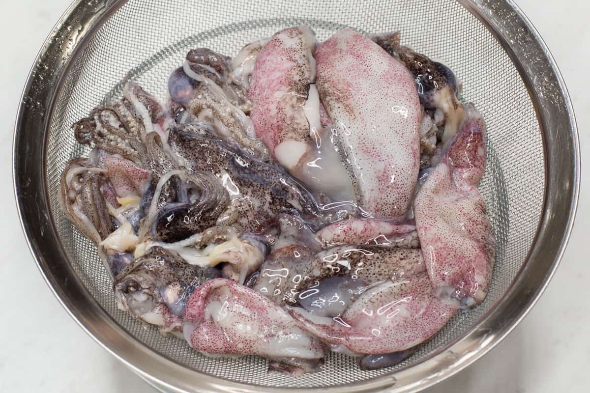 Straining the squid over a bowl.