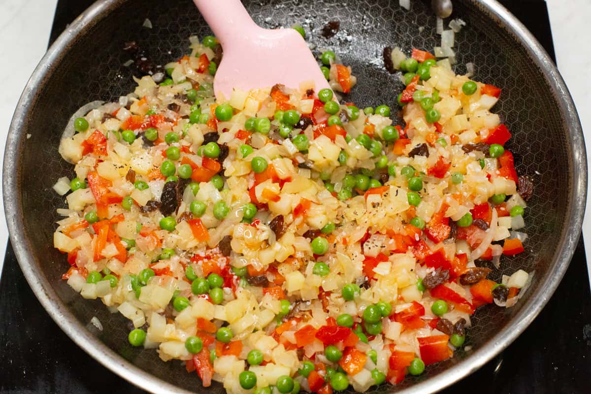 Sauteed aromatics and vegetables in a skillet.