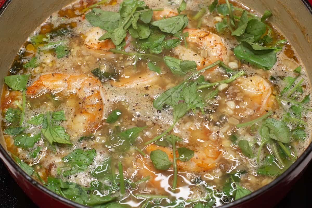 Corn soup with shrimp and greens in the pot.