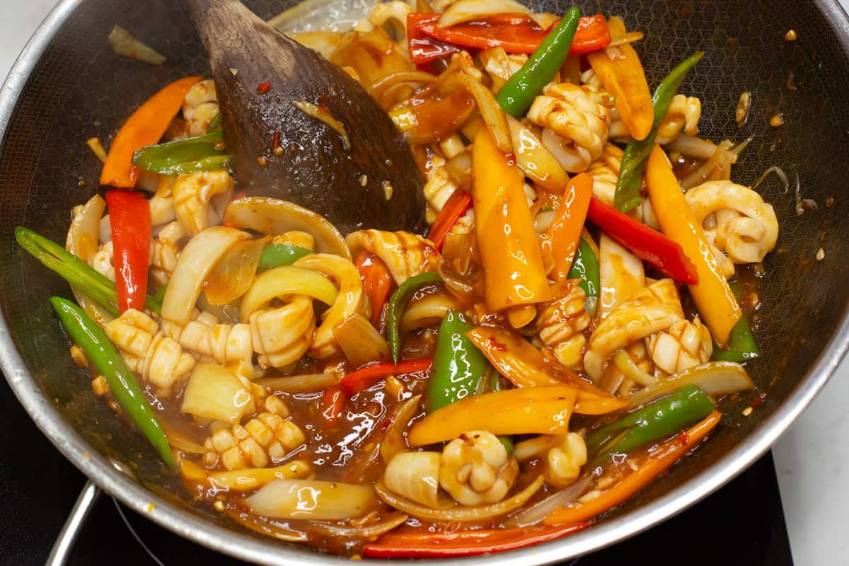 Mixing the Squid Stir fry in a wok.