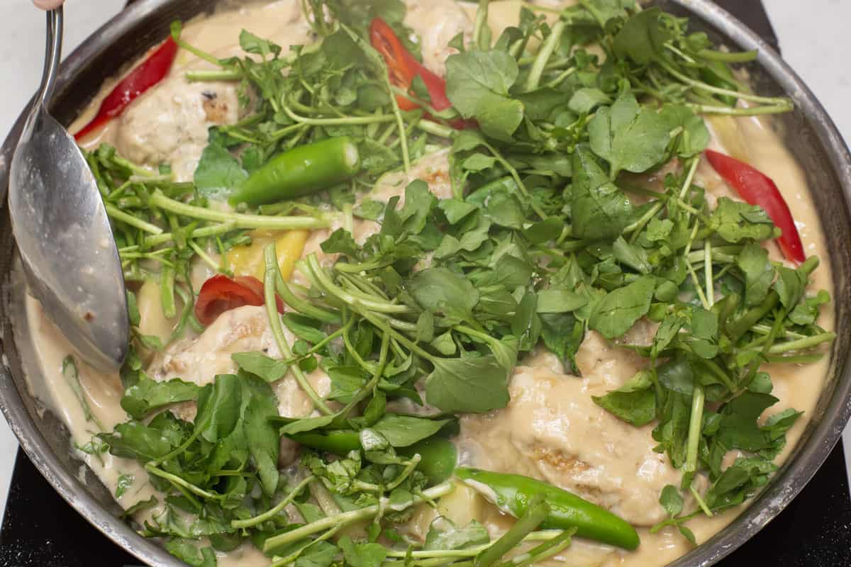 Watercress with the chicken in the wok.