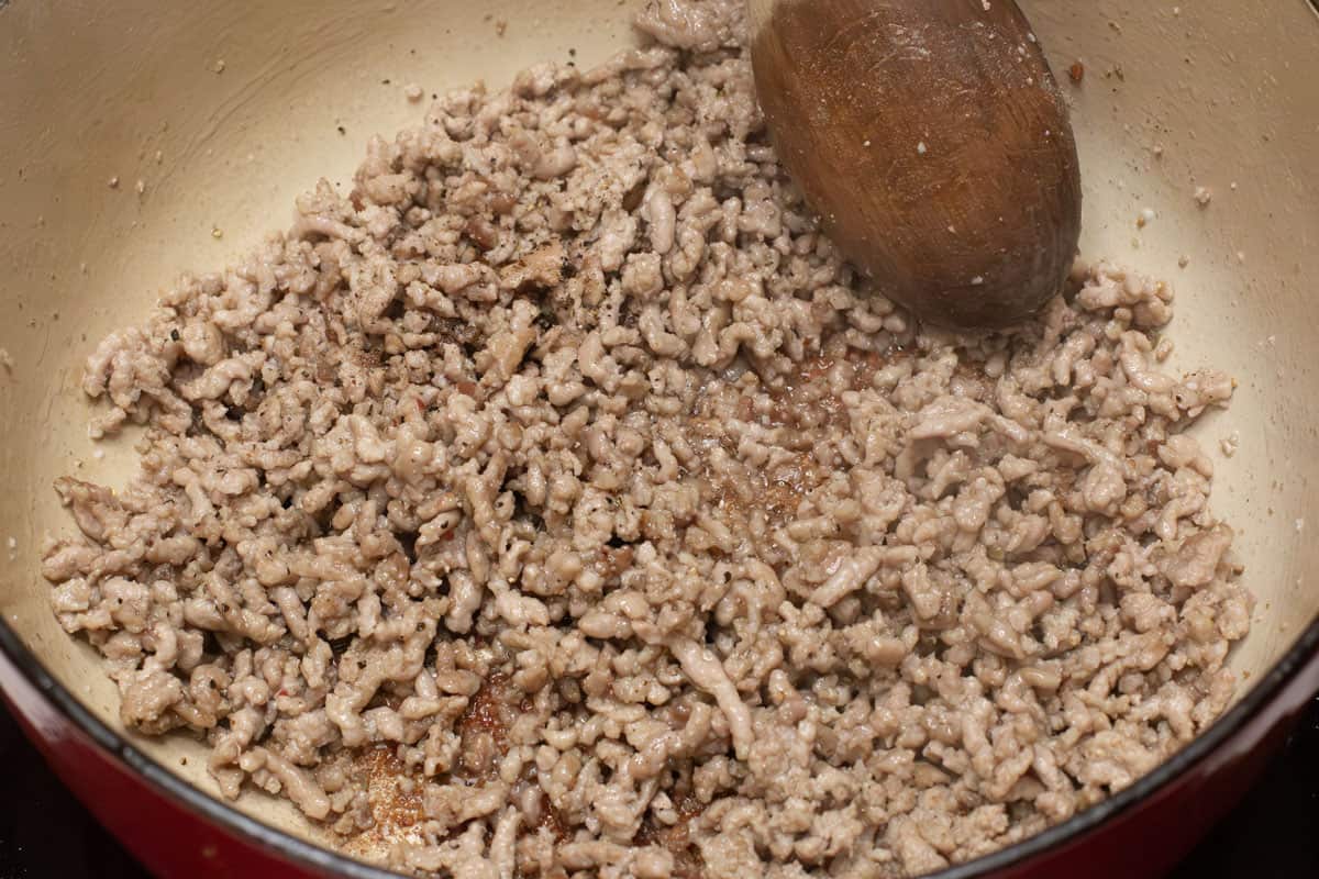 Browning the ground pork in the pot.
