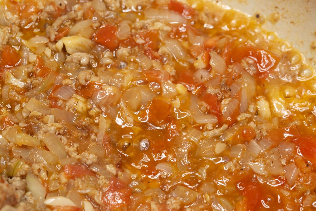 Sauteing the aromatics and ground pork in the pot.