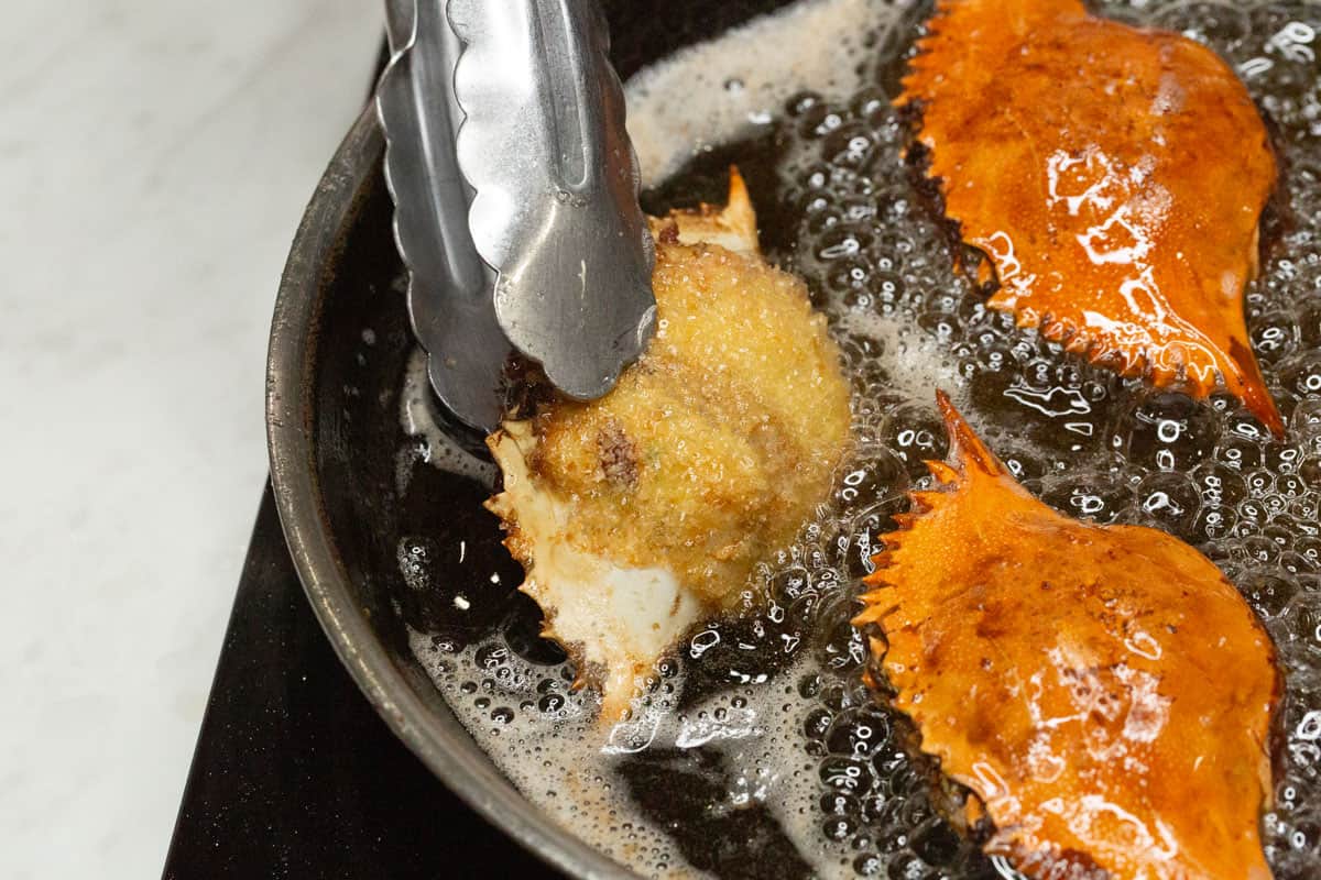 Flipping the crab relleno in a skillet.