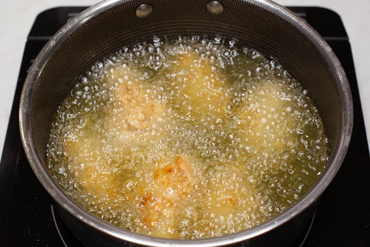 Frying the chicken in a saucepan.