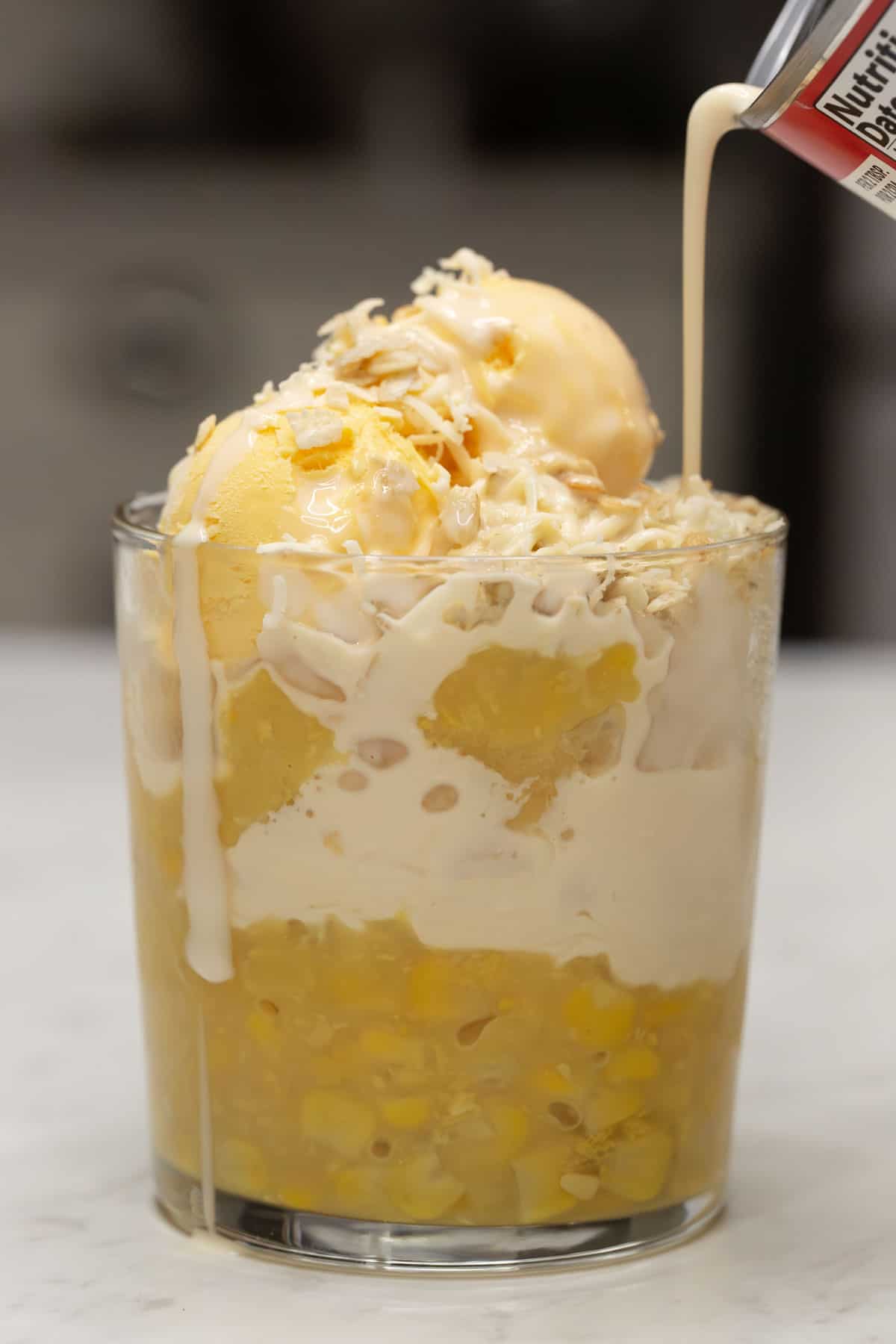 Pouring milk over the Mais con Yelo.