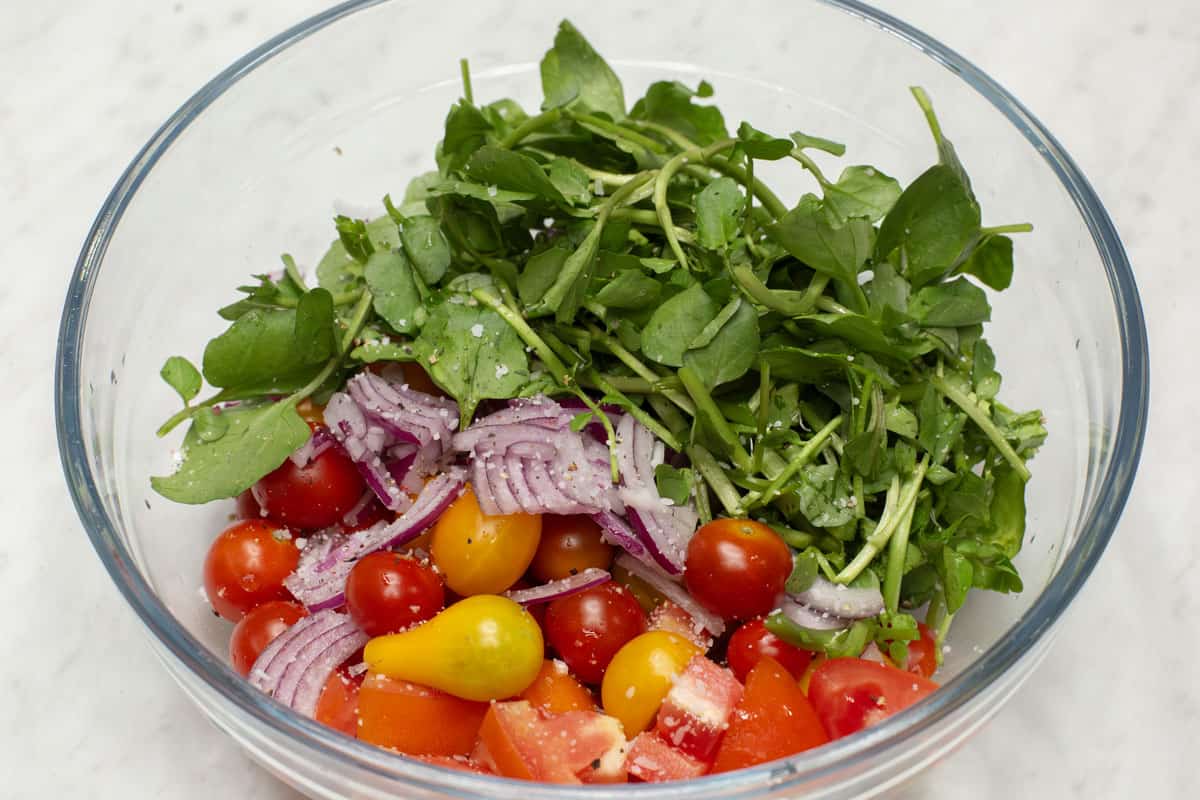 Tomatoes, red onions and watercress in a bowl