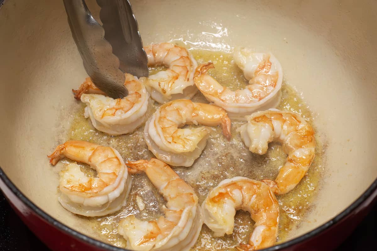 Searing the shrimp in a pot.