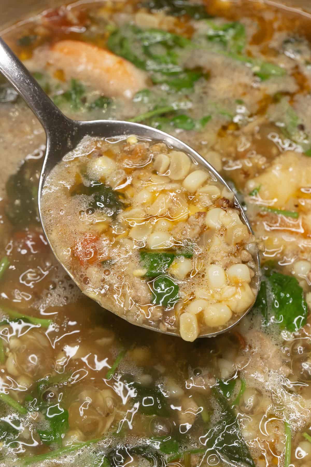 Filipino Corn Soup in a spoon over the pot.