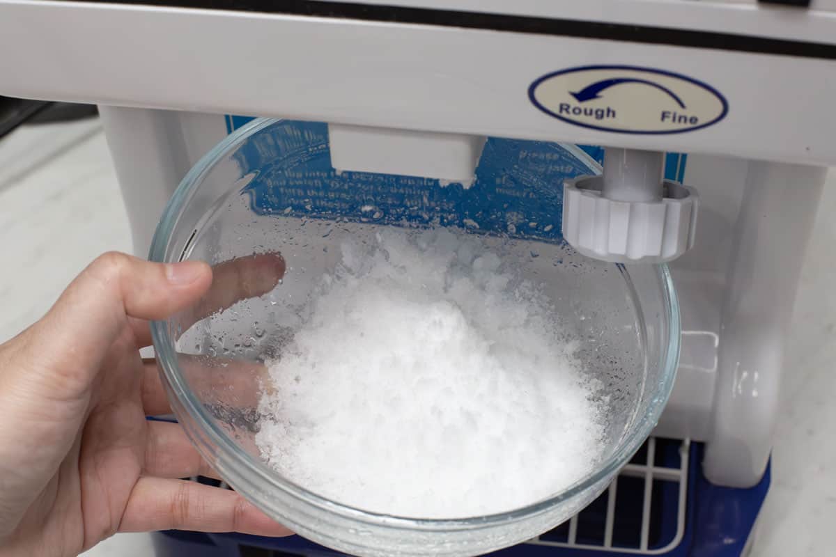 Shaving ice into a bowl.