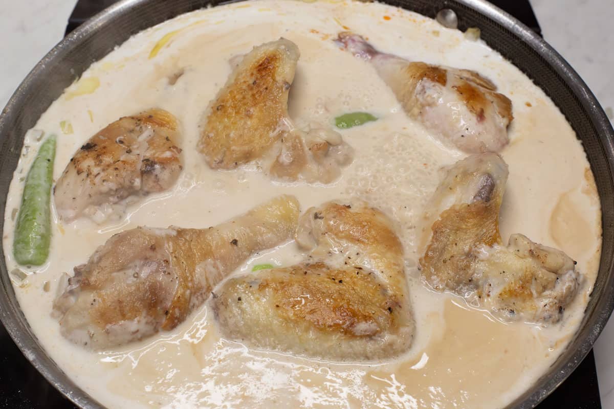Simmering the chicken in coconut milk.