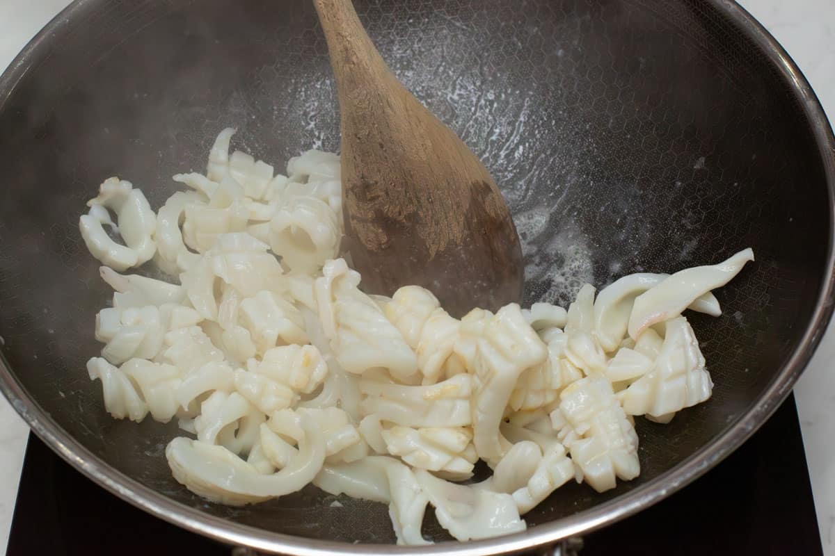 Stir frying the squid in a wok.