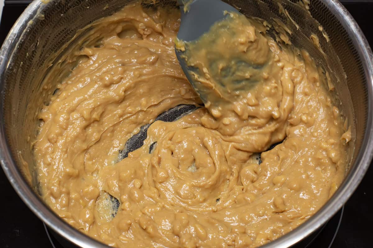 Mixing the thickened yema candy in the saucepan.