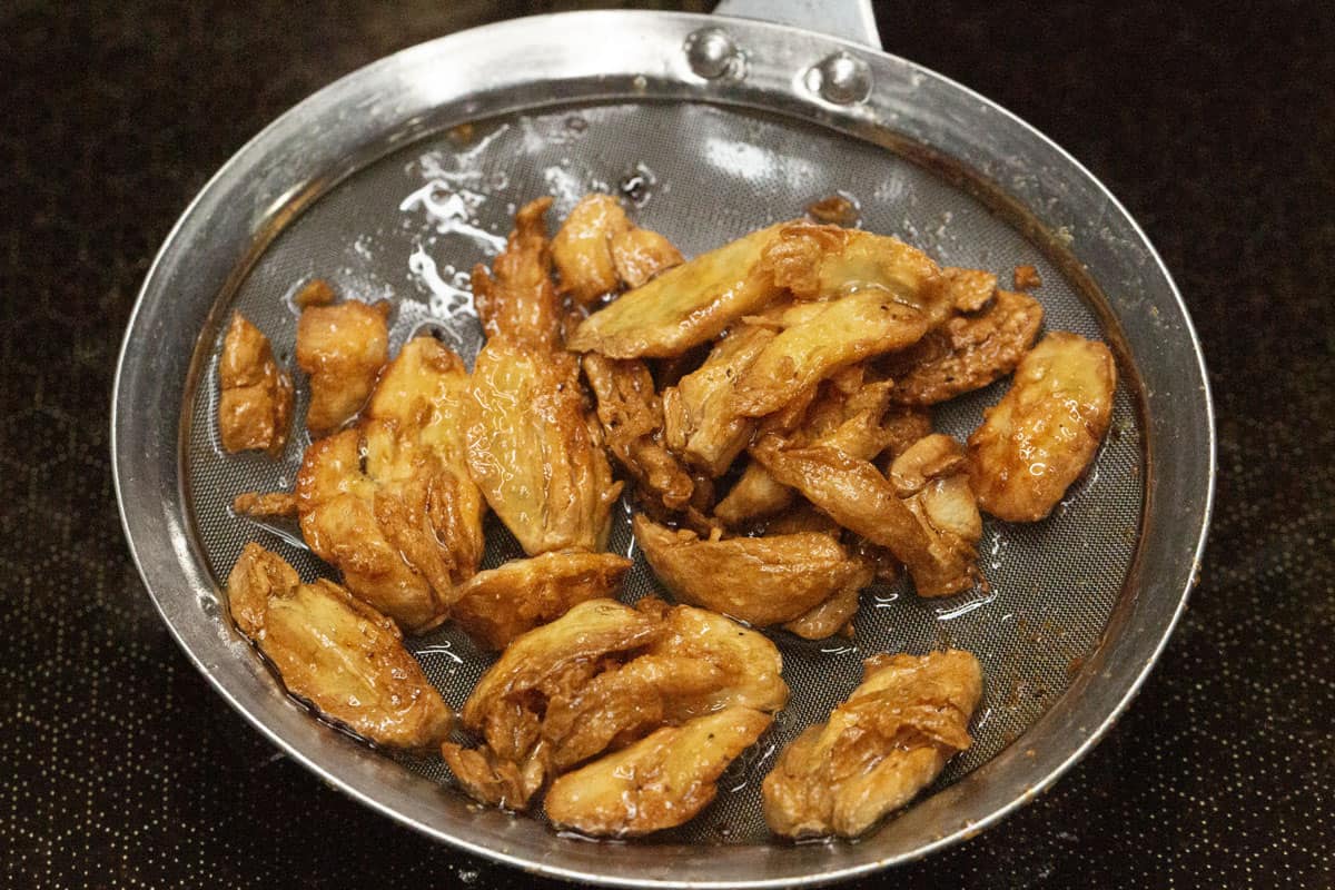 Fried garlic in a skimmer.