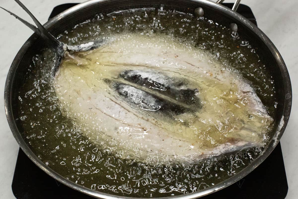 Milkfish frying in a skillet.