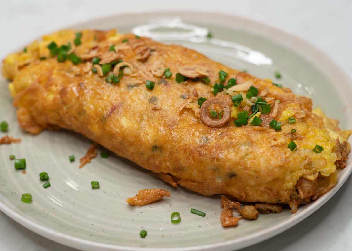 Tortang alimasag with scallions and fried onions on a plate.