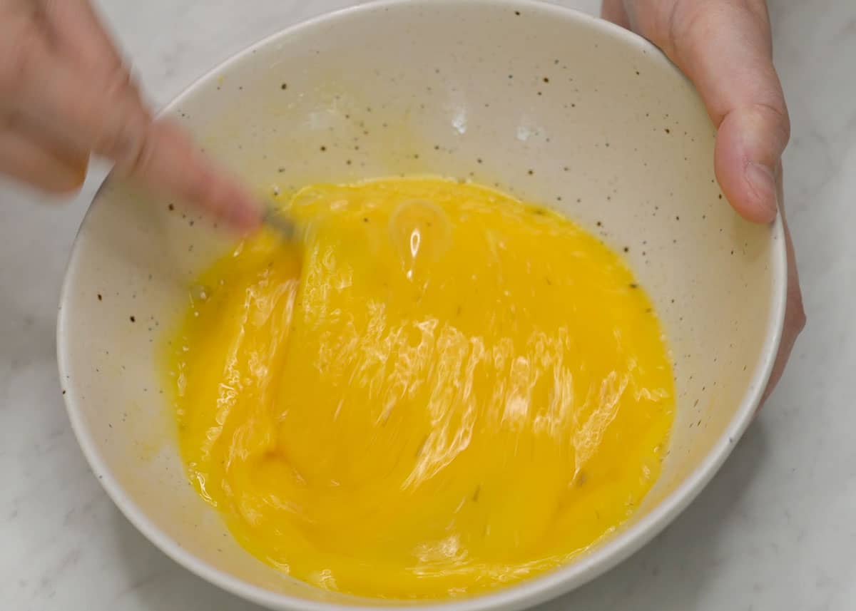 Beating the eggs in a bowl.