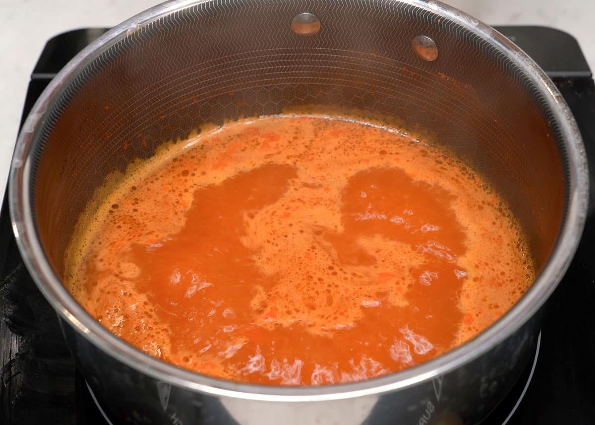 Boiling water with achuete powder in a pot.