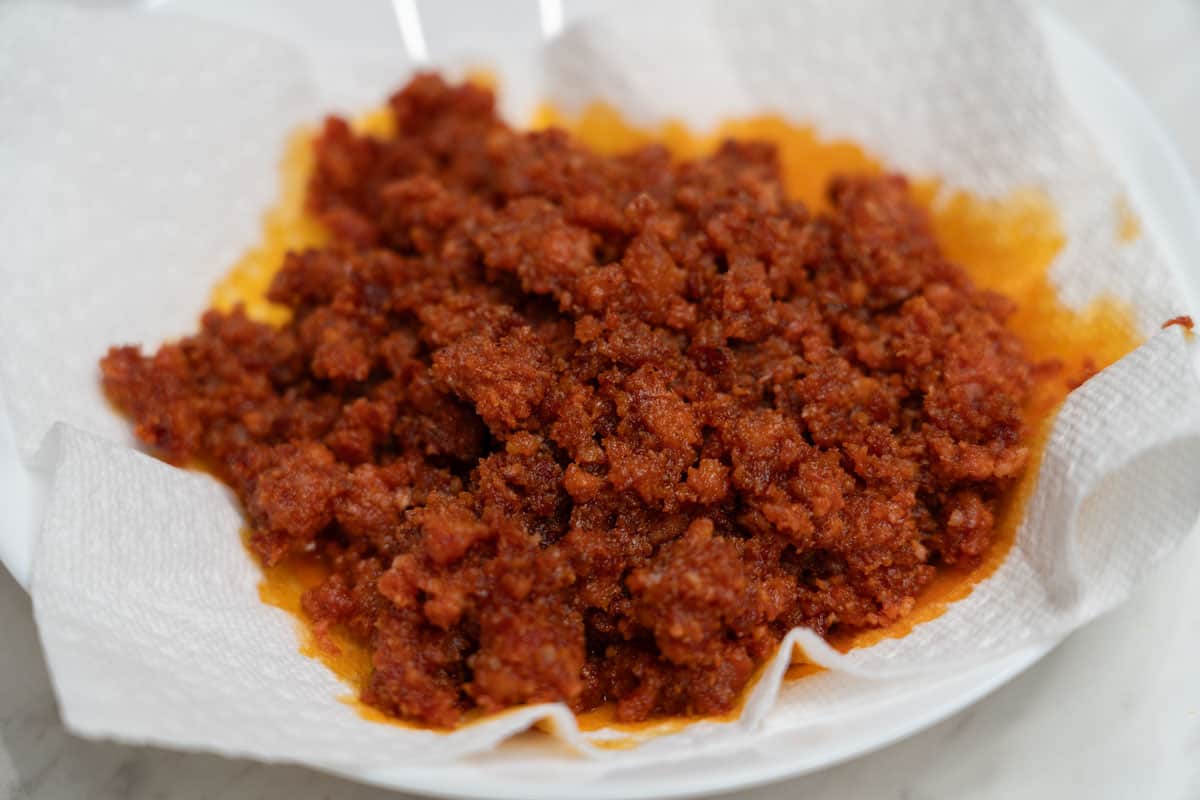 Cooked longganisa on a paper towel-lined plate.