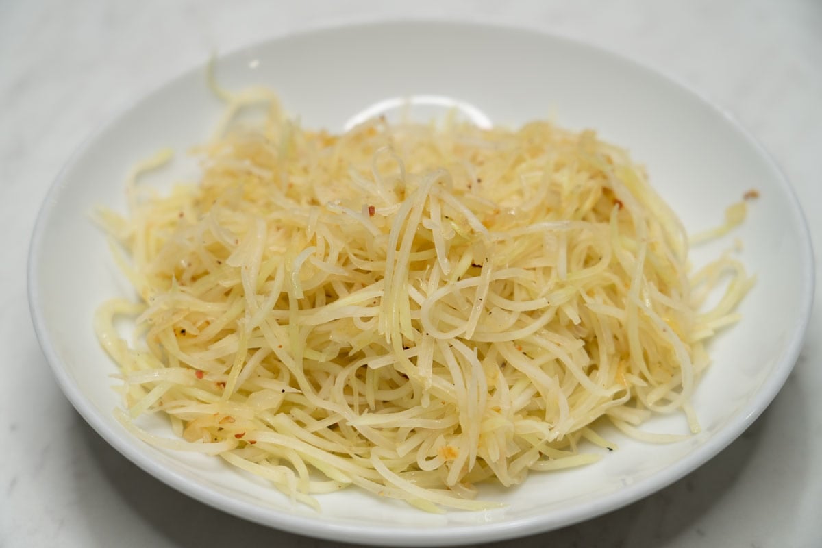 Cooked shredded green papaya on a plate.