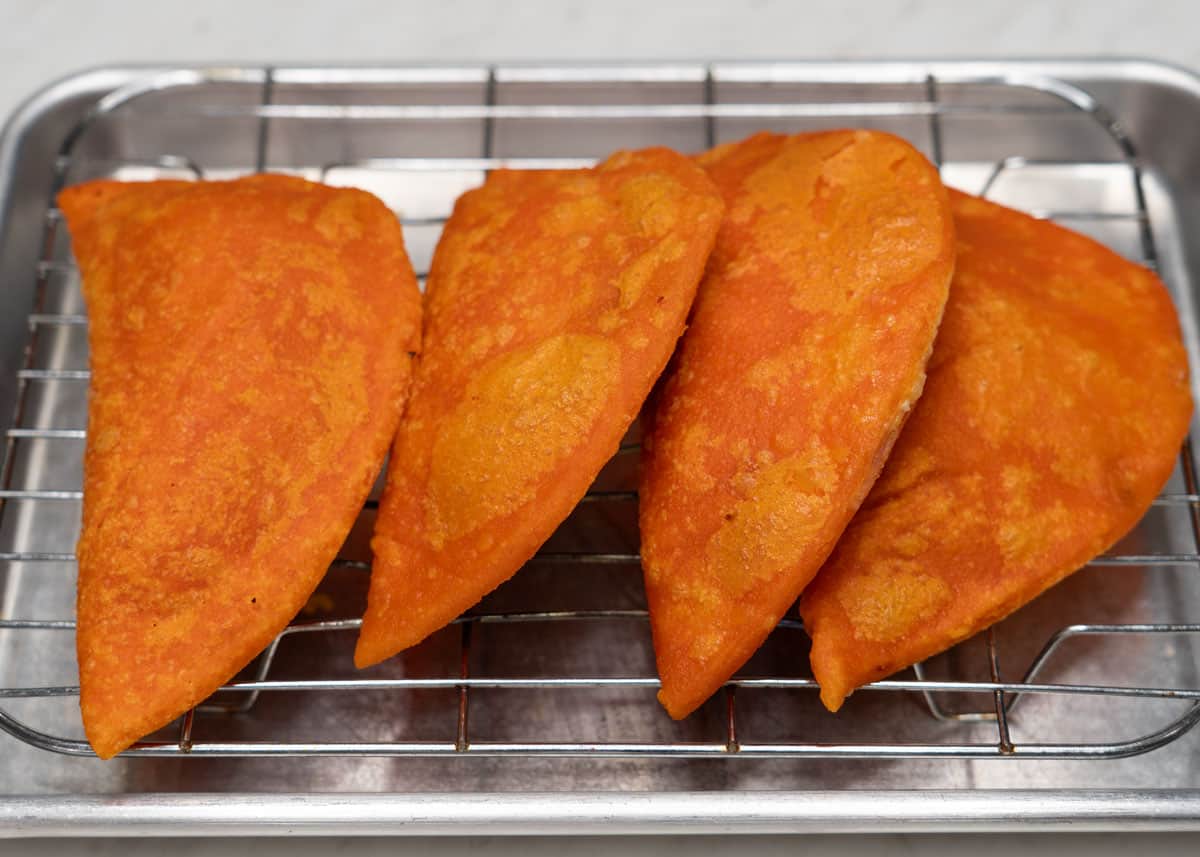 Fried Ilocos empanada (Vigan-style) on a wire rack.