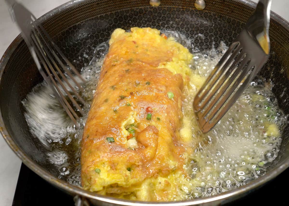Flipping the Tortang alimasag (crab omelet) in the pan.