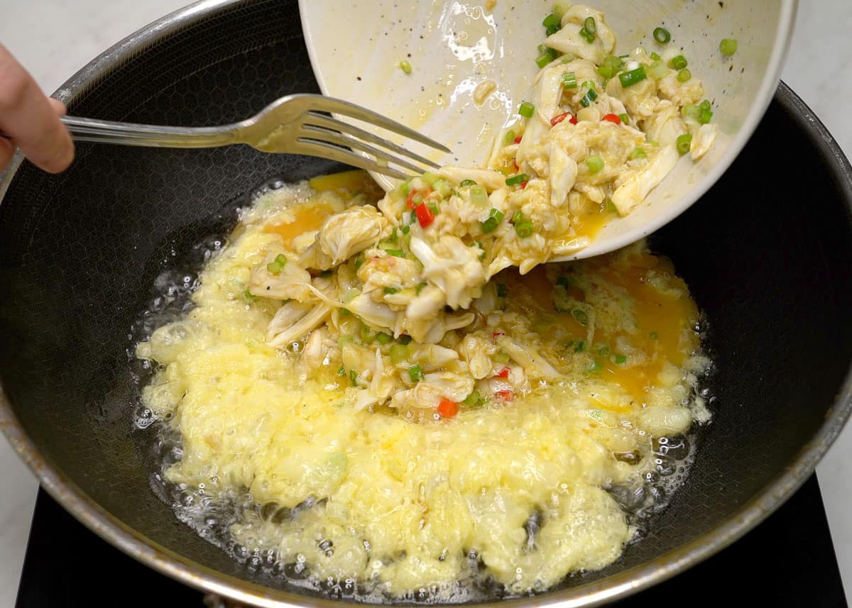 Pouring the rest of the crab and egg mixture into the pan.