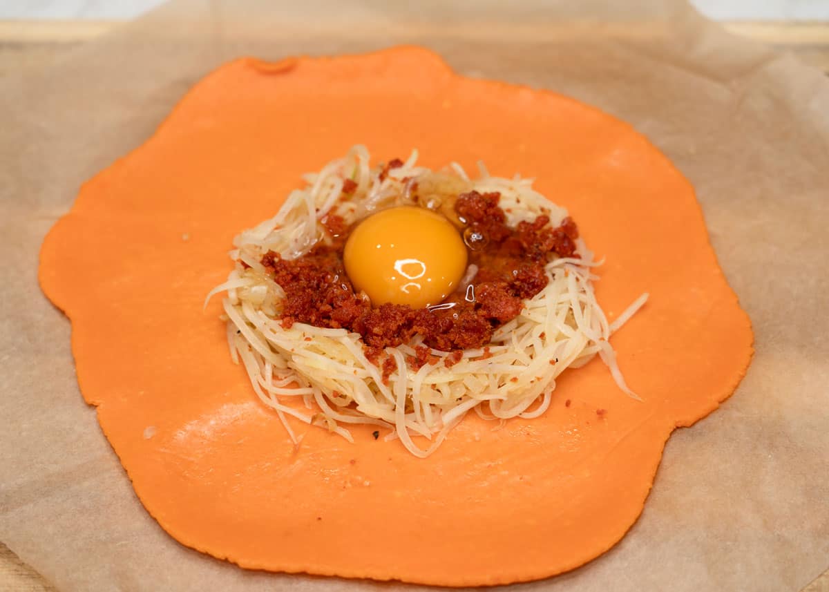 Rolled empanada dough with filling in the center.