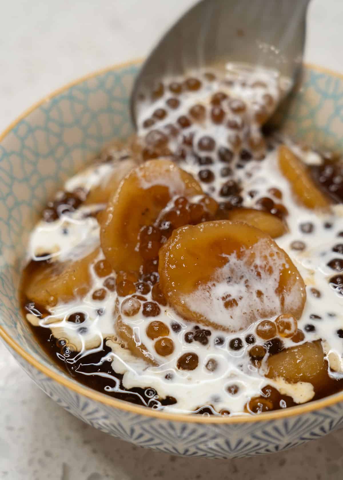 Minatamis na Saging (Sweetened Saba Bananas) with cream in a bowl.