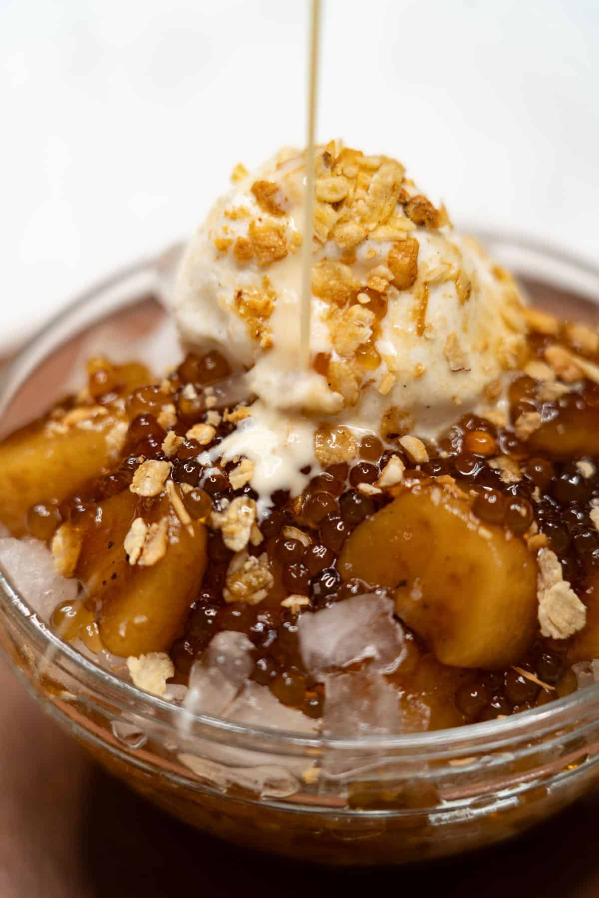 Pouring milk over saging con yelo (sweetened bananas with ice and milk).