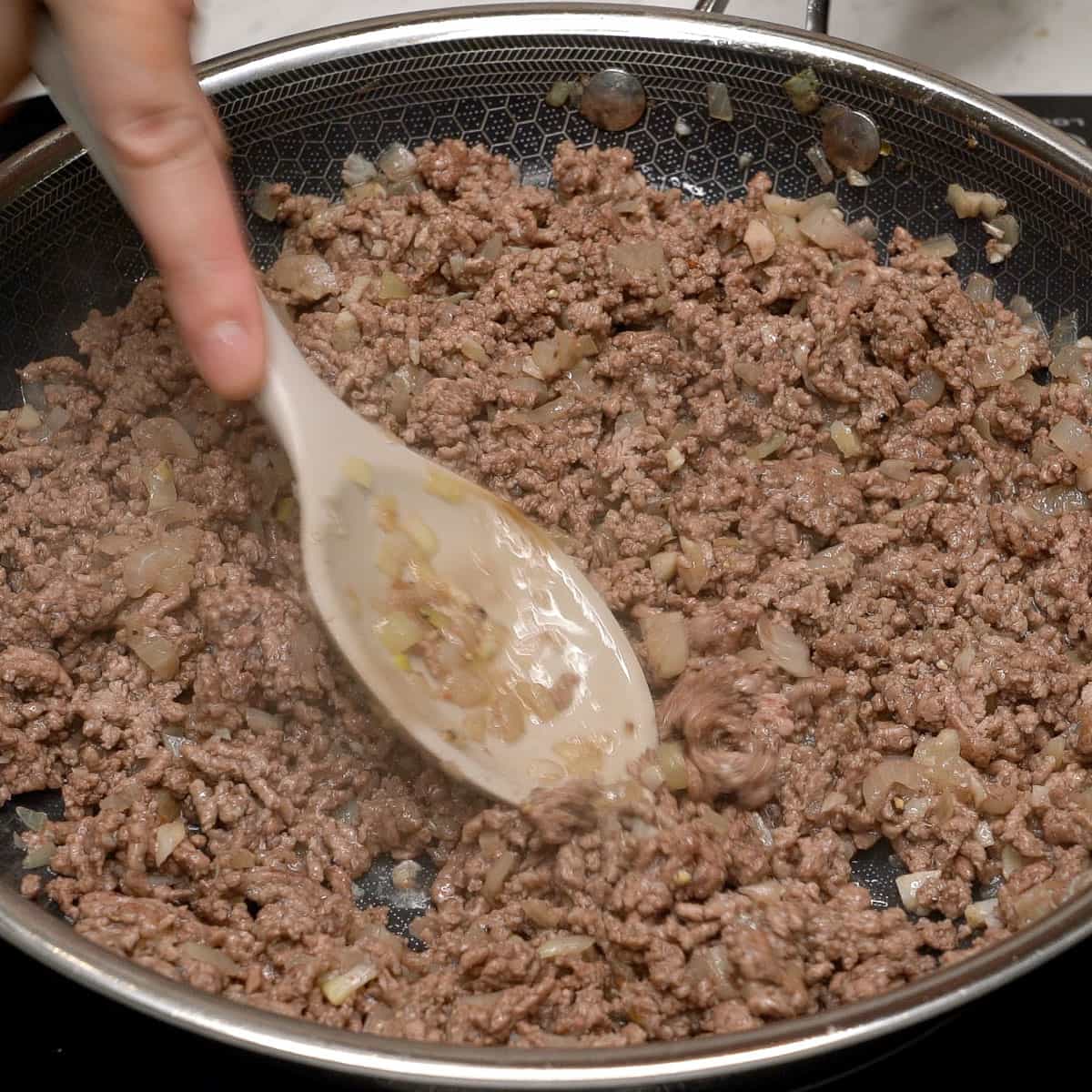 Browning the meat in a pan.