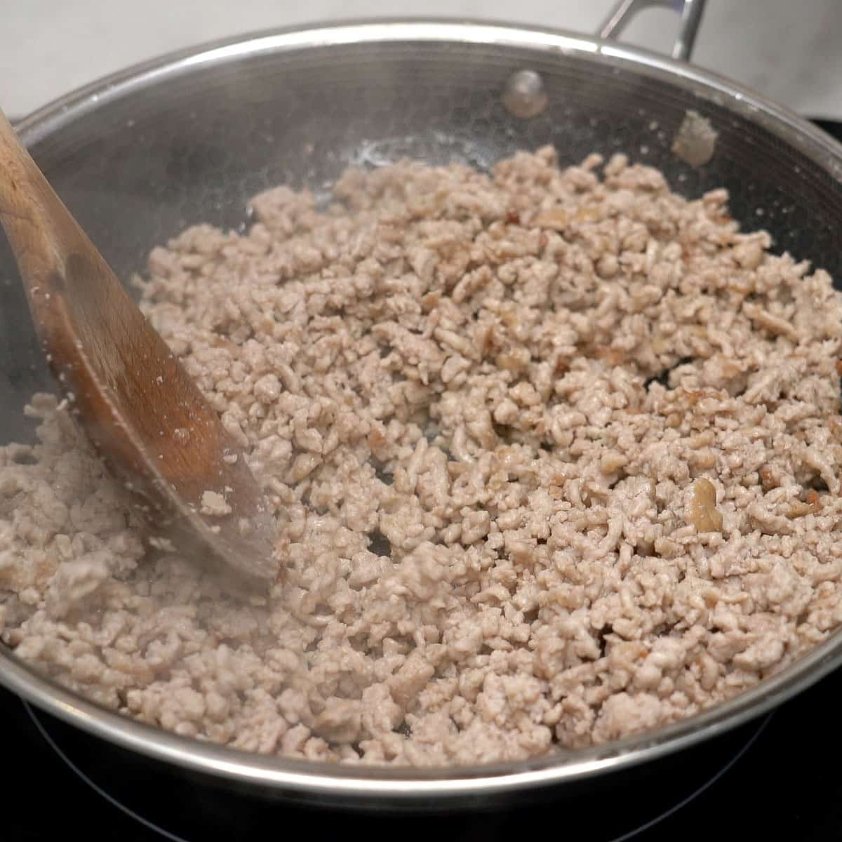 Browning the pork in the pan.