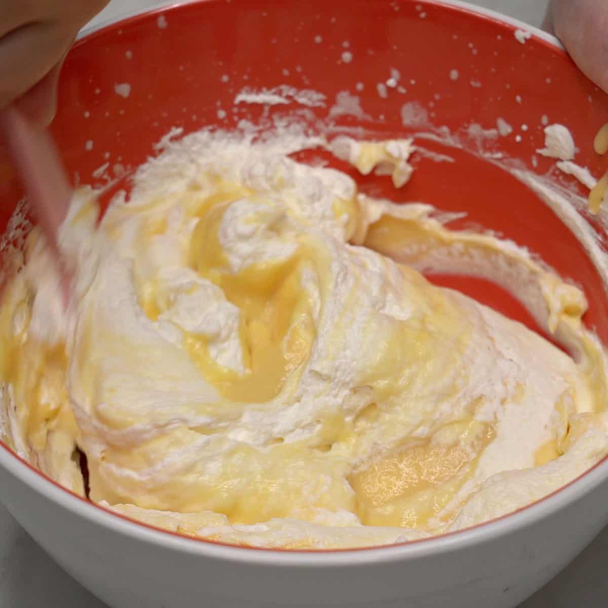 Combining the pudding mixture and whipped cream in a bowl.