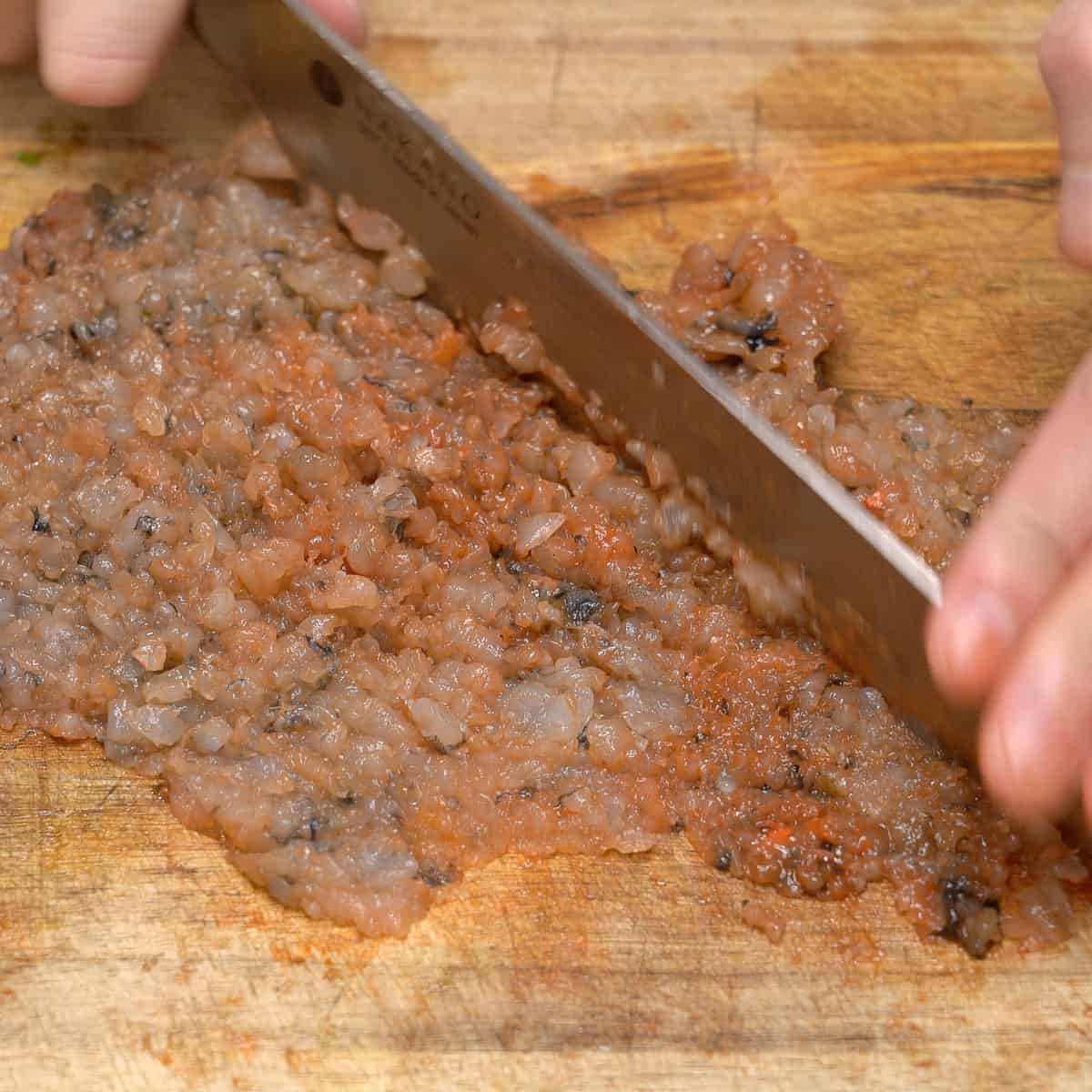 Chopping shrimp on a cutting board.