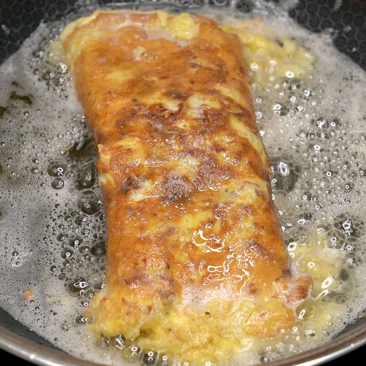 Tortang corned beef in a pan.